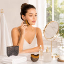 Mulher usando a escova facial no contorno do rosto durante a rotina de skincare.