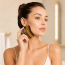 Mulher usando a escova facial no contorno do rosto durante a rotina de skincare.

