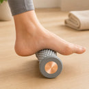 Pessoa usando o Rolo Massageador para Pés para aliviar a tensão na sola e no calcanhar.

